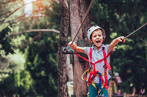 Ein Kind klettert im Abenteuerpark Kressbronn