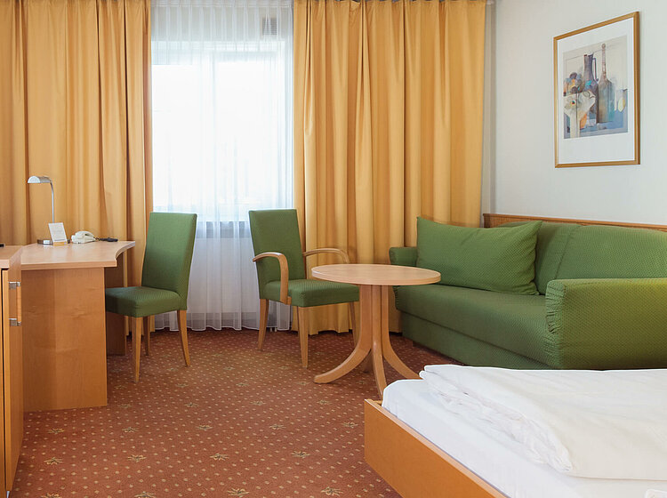 Hotelzimmer mit Doppelbett und Sofaecke